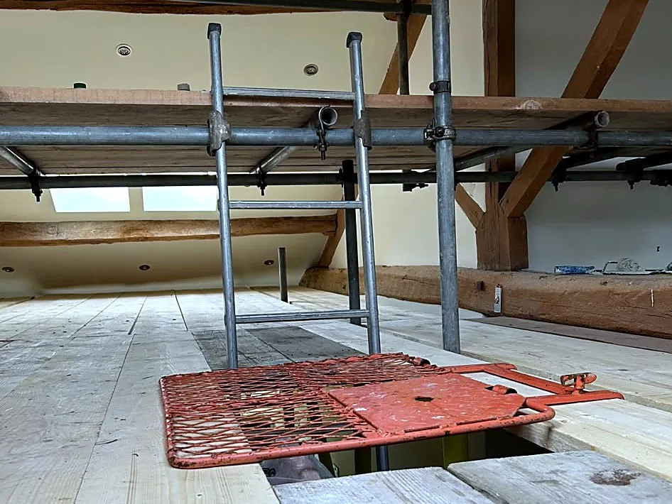 Birdcage scaffold with boarded platform through a loft space