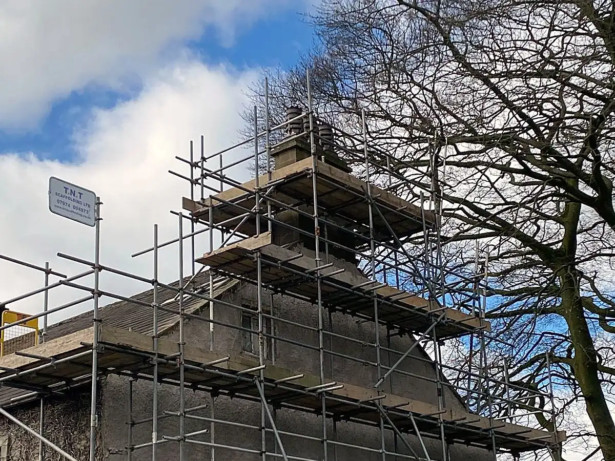 Chimney scaffold at roof level against a blue sky