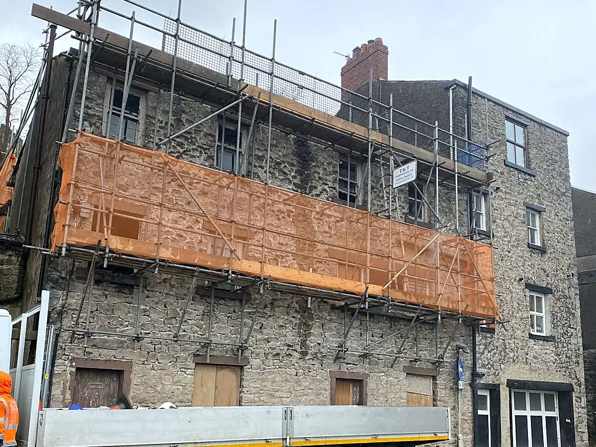 Custom scaffold with debris netting on a town-centre building