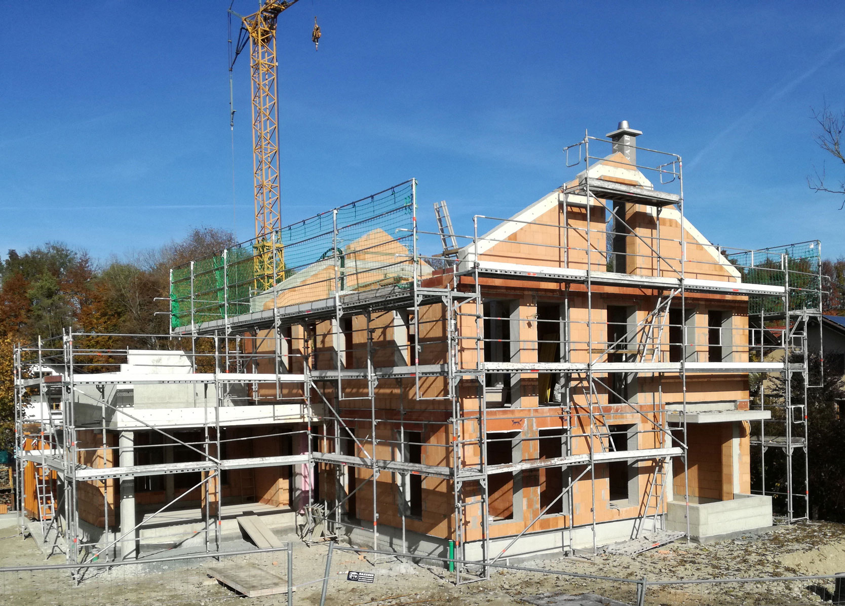 Scaffold around a new-build house against a blue sky
