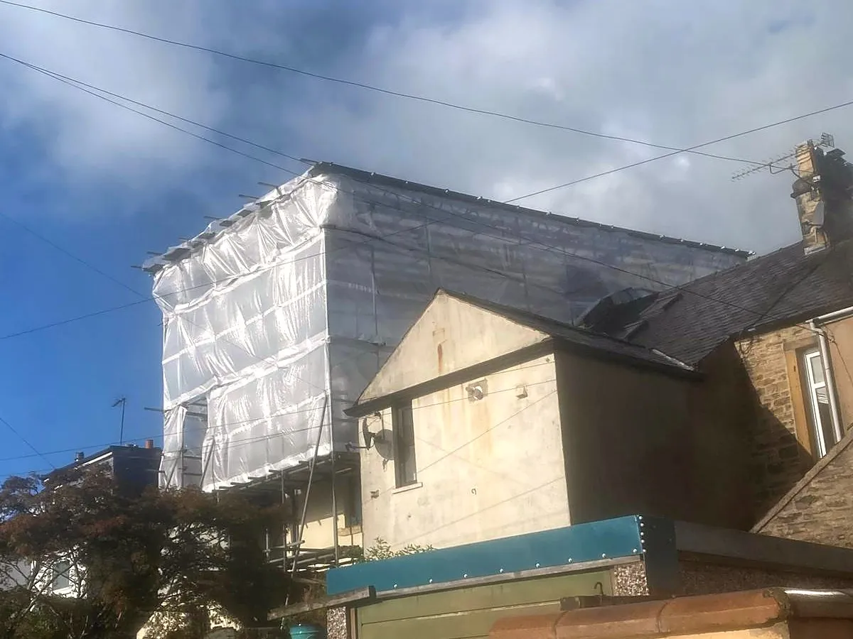 Sheeted temporary roof over a domestic property