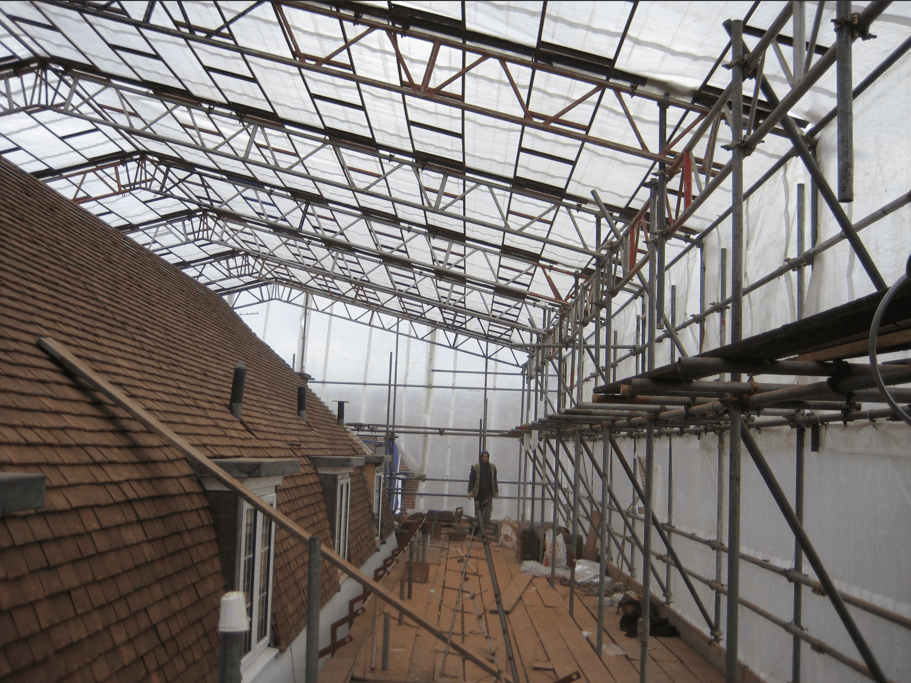 Scaffold-supported temporary roof over a building
